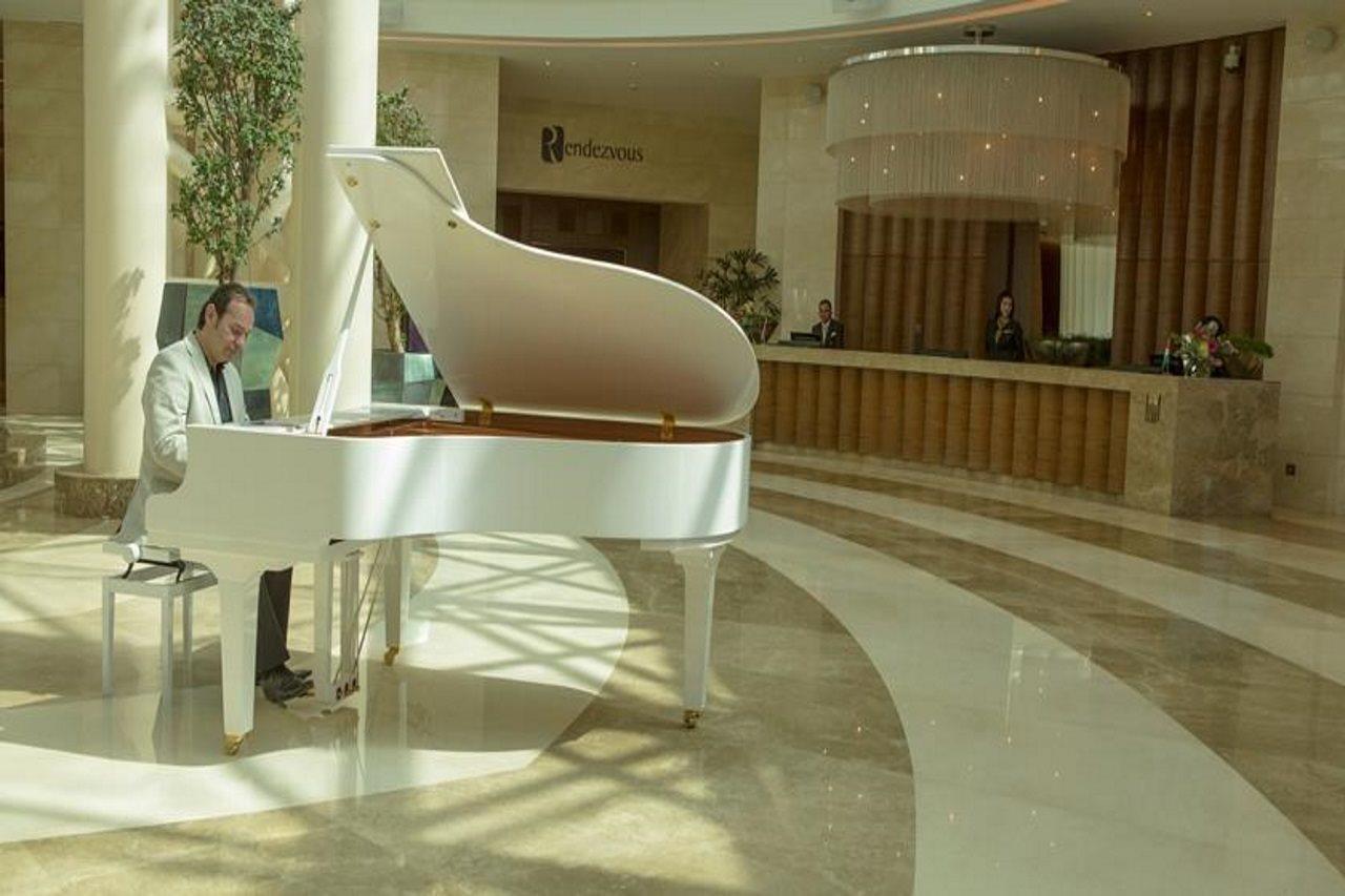 Grand Millennium Sulaimani Hotel Sulaymaniyah Exterior photo A piano player at the lobby of the Emirates Palace Hotel